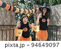 ハロウィンのコスチュームを着てトリックオアトリートをしている女の子2人 94649097