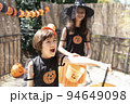 ハロウィンのコスチュームを着てトリックオアトリートをしている女の子2人 94649098