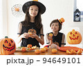 ハロウィンのコスチュームを着てパーティの準備をしている女の子2人 94649101