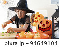 ハロウィンのコスチュームを着てパーティの準備をしている女の子 94649104