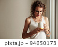 Pensive mature woman looking inside empty cup of coffee 94650173