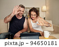 Mature stylish glam rock couple smiling and waving at camera on tablet computer 94650181