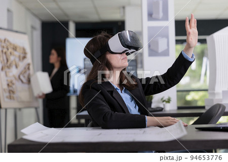 Architect in ar helmet touching virtual building model, working on project in metaverse. Employee engineering in virtual reality, real estate agency worker in vr headset in architecture office Architect in ar helmet touching virtual building model, working on project in metaverse. Employee engineering in virtual reality, real estate agency worker in vr headset in architecture office 94653776
