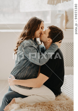 pregnant woman and man. a couple kissing on the bed. 94655380