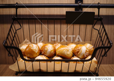 Bread buns in a black basket. 94655920