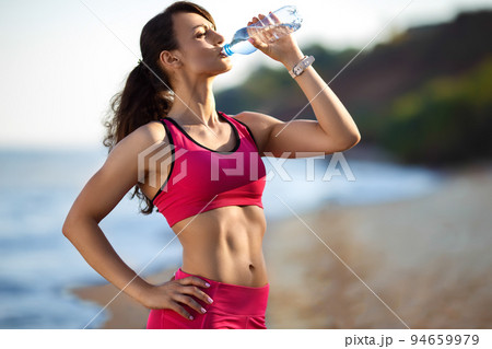 Fitness runner woman running on beach. Sporty athlete training cardio barefoot with determination. Fitness runner woman running on beach. Sporty athlete training cardio barefoot with determination. 94659979