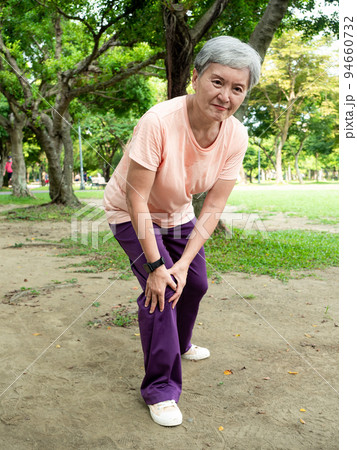 Portrait of mature asian woman 60s with knee pain at park outdoor. Portrait of mature asian woman 60s with knee pain at park outdoor. 94660732