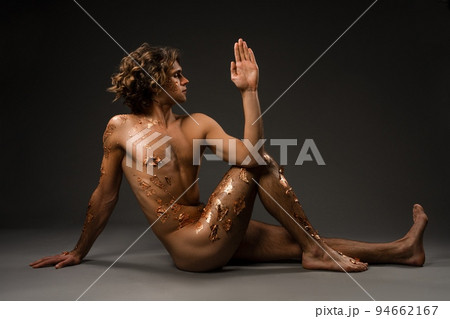 Naked young man doing Seated Spinal Twist pose 94662167