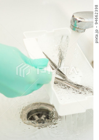 Hand in glove cleans the tweezers with water in-tray. Cleaning systems for tweezers Hand in glove cleans the tweezers with water in-tray. Cleaning systems for tweezers 94662398