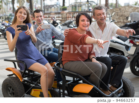 family of tourists enjoy a walk on the bike carriage family of tourists enjoy a walk on the bike carriage 94663257