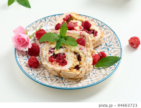 Baked meringue roll with cream and fresh red raspberry, white background Baked meringue roll with cream and fresh red raspberry, white background 94663723