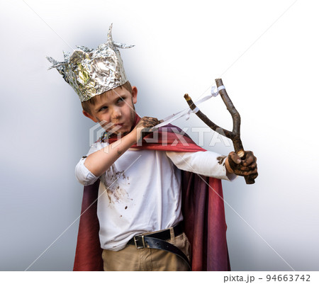 Dirty boy aiming with a slingshot 94663742