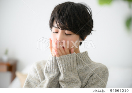 寒くて口に手を当てる女性 寒くて口に手を当てる女性 94665010