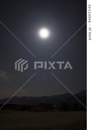 よく晴れた満月の夜に原っぱで撮影した星空の写真（星景写真）の縦写真 94665540