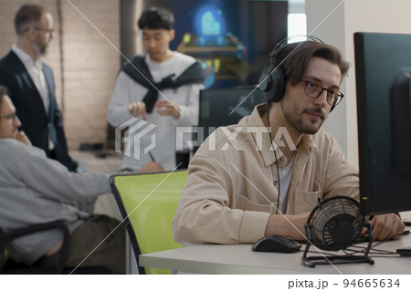Caucasian male artist designer in glasses draws on a tablet a 3D model  94665634
