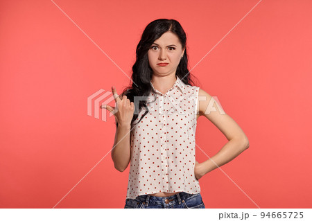 Studio shot of a beautiful girl teenager posing over a pink background. 94665725