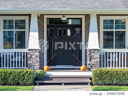 Decorative ripe pumpkins laying in front the house entrance 94665996