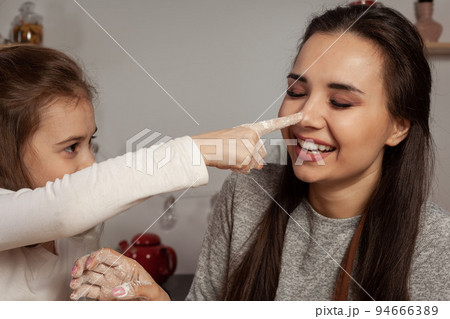 Mother and her daughter are baking a bread and having fun at the kitchen. Mother and her daughter are baking a bread and having fun at the kitchen. 94666389