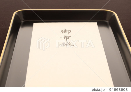 お盆にのせられた僧侶に渡すお布施の封筒 葬儀葬式にかかるコストのイメージ3 お盆にのせられた僧侶に渡すお布施の封筒 葬儀葬式にかかるコストのイメージ3 94668608