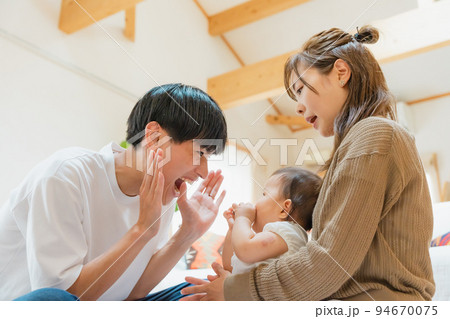 リビングで子供をあやす夫婦 94670075