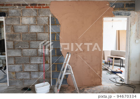 Plastering of concrete block wall. making the wall even with brown plaster 94670334