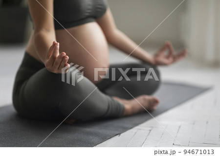 Closeup Shot Of Unrecognizable Expectant Woman Meditating In Lotus Position At Home 94671013