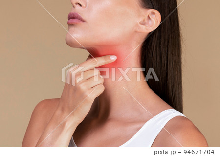 Closeup of unrecognizable sick lady suffering from sore throat, touching neck with hand, inflamed red zone 94671704