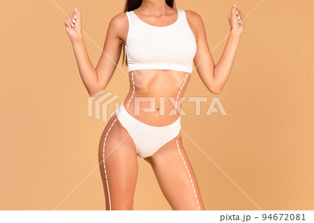 Body shaping concept. Fit lady in underwear with drawn lifting up lines on torso and hips, collage, cropped Body shaping concept. Fit lady in underwear with drawn lifting up lines on torso and hips, collage, cropped 94672081