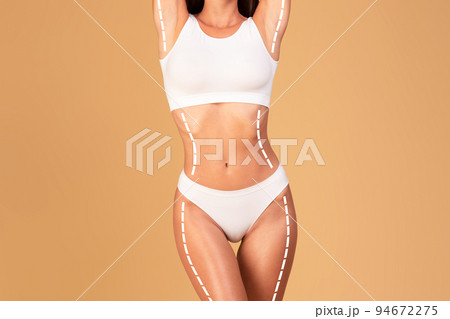 Slimming and tightening concept. Cropped shot of lady in underwear posing with massage lines and arrows on her body 94672275