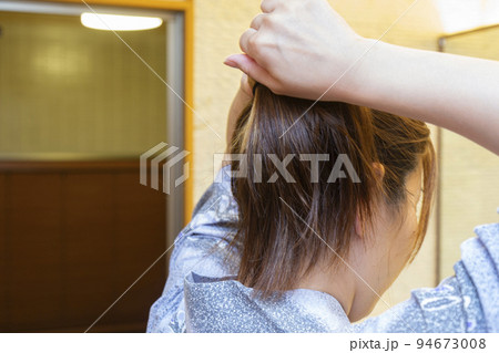 旅館で髪の毛を束ねる女性の後ろ姿 旅館で髪の毛を束ねる女性の後ろ姿 94673008