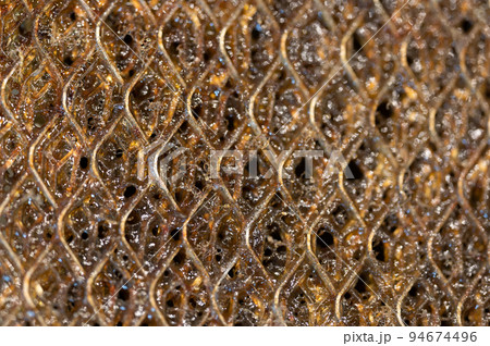 Selective focus macro of a dirty kitchen range hood filter clogged with grease. 94674496