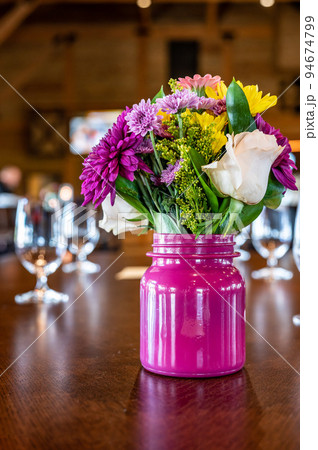 Flower arrangement on a formal dinning table with dim lighting. Flower arrangement on a formal dinning table with dim lighting. 94674799