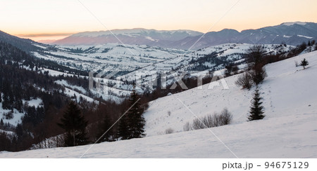 carpathian rural landscape in winter. beautiful sunrise in mountains. snow covered hills. scenery with krasna ridge in the distance. synevir village in the valley carpathian rural landscape in winter. beautiful sunrise in mountains. snow covered hills. scenery with krasna ridge in the distance. synevir village in the valley 94675129