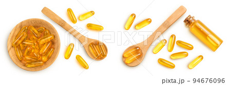 Fish oil capsules in wooden bowl isolated on white background with full depth of field. Top view. Flat lay Fish oil capsules in wooden bowl isolated on white background with full depth of field. Top view. Flat lay 94676096