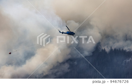 Wildfire Service Helicopter flying over BC Forest Fire and Smoke on the mountain near Hope Wildfire Service Helicopter flying over BC Forest Fire and Smoke on the mountain near Hope 94676726