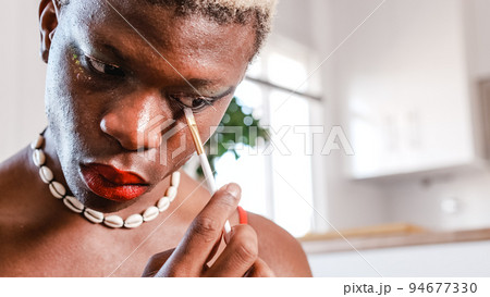 Black man applying makeup at home Black man applying makeup at home 94677330