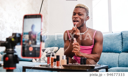 Transgender beauty blogger applying makeup to mobile phone camera 94677333