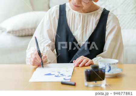 リビングで手紙を書くグレイヘアの女性 94677861