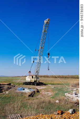 Big Power Mobile Crane on a road and tower crane in construction site Big Power Mobile Crane on a road and tower crane in construction site 94678083