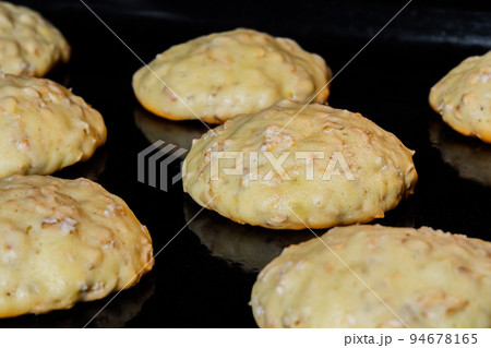 Cooking many homemade crunchy oatmeal cookies on metal sheet in oven Cooking many homemade crunchy oatmeal cookies on metal sheet in oven 94678165