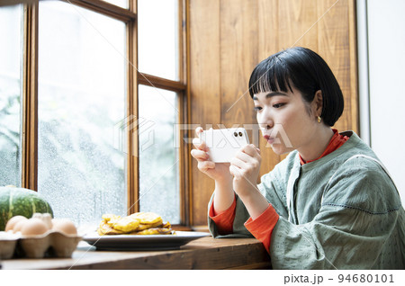 自家製パンケーキの写真を撮影する若い女性 自家製パンケーキの写真を撮影する若い女性 94680101