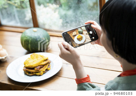自家製パンケーキの写真を撮影する若い女性 自家製パンケーキの写真を撮影する若い女性 94680103