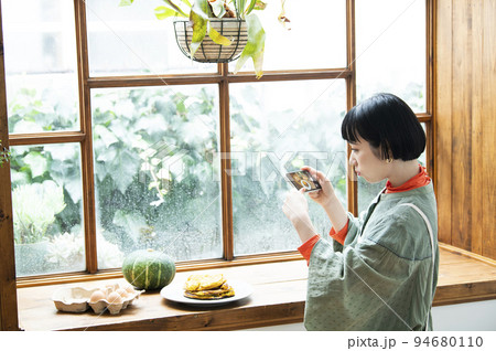 自家製パンケーキの写真を撮影する若い女性 94680110