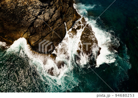 Aerial view of waves crashing on rocks,Seascape birds eye view photo shot over ocean waves, Image for nature background and travel background,Amazing seashore at Phuket island thailand Aerial view of waves crashing on rocks,Seascape birds eye view photo shot over ocean waves, Image for nature background and travel background,Amazing seashore at Phuket island thailand 94680253