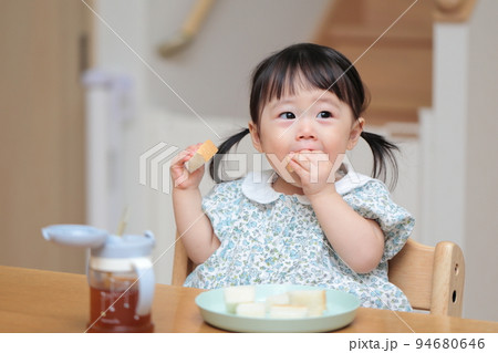 パンを手づかみ食べする1歳の女の子 94680646