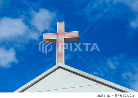 Faded cross on church roof 94681618