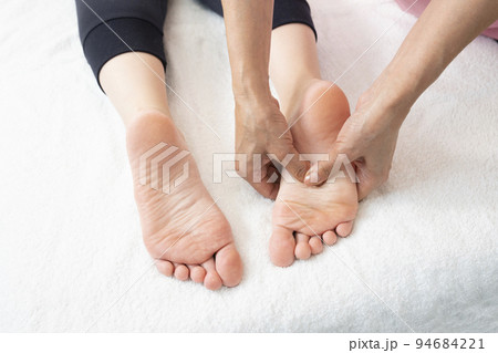 足裏のマッサージをする整体師の手元 94684221
