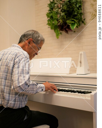 老後の趣味にピアノを習い始めた高齢男性 94688611