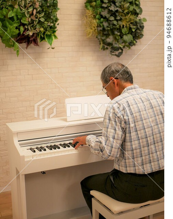老後の趣味にピアノを習い始めた高齢男性 94688612