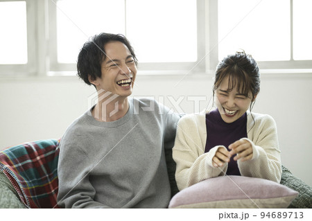 ソファでくつろぐ若いカップル ソファでくつろぐ若いカップル 94689713